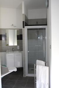 a bathroom with a glass shower and a sink at Hotel-Restaurant Du Port in Mèze +63 photos