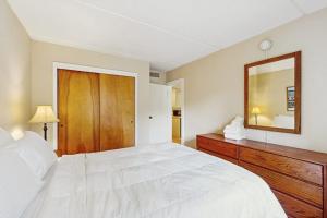 a bedroom with a large white bed and a mirror at Seasons 200 in Warren
