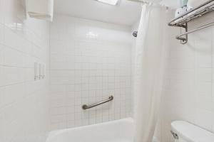 a white bathroom with a shower and a toilet at Seasons 200 in Warren +7 photos