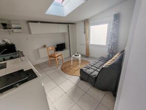 a living room with a couch and a table at Studio pour 1 ou 2 personnes in Le Landreau