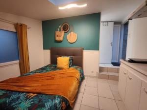 a bedroom with a bed and a green wall at Studio pour 1 ou 2 personnes in Le Landreau