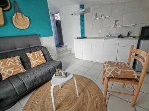 a living room with a black couch and a table at Studio pour 1 ou 2 personnes in Le Landreau +4 photos