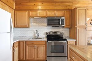 a kitchen with a stove and a microwave at Chalet #16 in Stevensville
