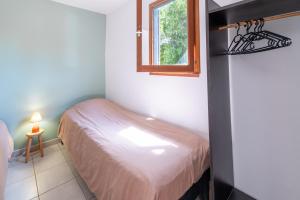 a small bedroom with a bed and a window at Case di Mare Chalet Bignone in Cervione