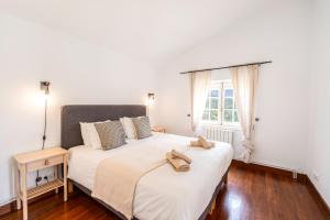 a bedroom with two beds with shoes on top of them at Casa da Figueira in Ericeira +96 photos