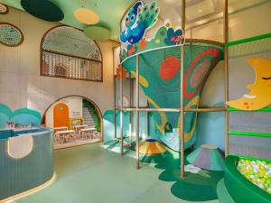 a childrens play area with a slide in a room at Pullman Phuket Karon Beach Resort in Karon Beach