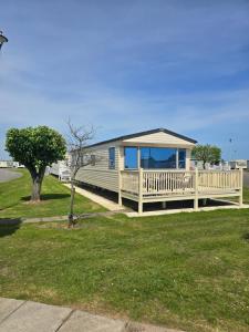a mobile home with a porch and a deck at Chasing The Dream k52, Ingoldmells, FREE WIFI in Ingoldmells