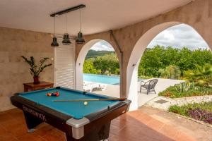 a pool table in a room with a swimming pool at Casa da Figueira in Ericeira