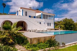 a house with a swimming pool in front of it at Casa da Figueira in Ericeira