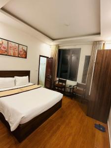 a bedroom with a bed and a desk in it at Phú Điền Motel in Ðại Sơn