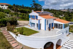 an aerial view of a white house with blue windows at Casa da Figueira in Ericeira