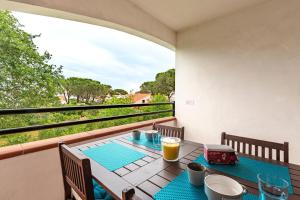 a table on a balcony with a drink on it at L'Escapade Corse - À 80 mètres de la plage in San-Nicolao