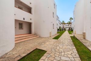 a stone walkway between two white buildings at L'Escapade Corse - À 80 mètres de la plage in San-Nicolao