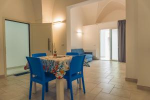 a dining room with a table and blue chairs at ADA Apartment in Porto Cesareo