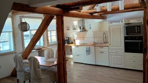 a kitchen with white cabinets and a table with chairs at Eulen- & Altstadtnest in Peine