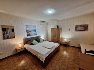 a bedroom with a large bed and two lamps at Apartmani Emi in Tučepi