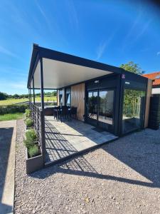 a modern house with a black roof and glass doors at Ancarano mobile house & whirlpool in Ankaran