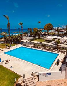 a swimming pool with a view of the ocean at PALLINIO COURT 402 Fig Tree Bay- Protaras Beach, IASONOS STR 7A in Protaras