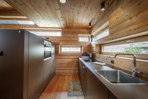 a kitchen with a stainless steel sink and wooden walls at Design Lodge The Cube in Ortisei +25 photos