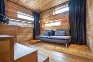 a living room with a couch and two windows at Design Lodge The Cube in Ortisei