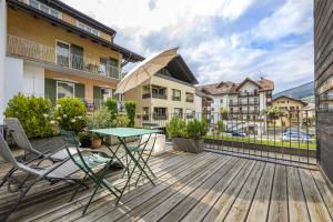 a patio with a table and chairs on a deck at Design Lodge The Cube in Ortisei