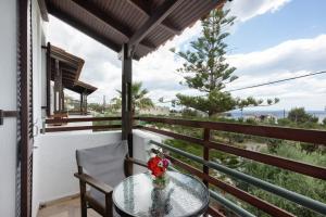 a table and chairs on a balcony with a tree at Apartment with sea view - Creta in Ferma +13 photos