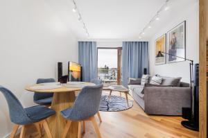 a living room with a table and chairs and a couch at BOOKS & SUN by the Sea Air-conditioned Apartment in Władysławowo