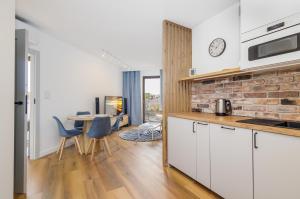 a kitchen and dining room with a table and chairs at BOOKS & SUN by the Sea Air-conditioned Apartment in Władysławowo