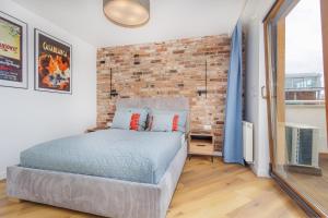 a bedroom with a brick wall and a bed at BOOKS & SUN by the Sea Air-conditioned Apartment in Władysławowo