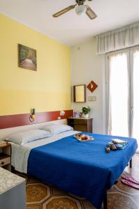 a bedroom with a blue bed with a blue blanket at Hotel Cesari in Rimini