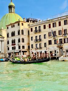 a gondola in the water in front of a building at Hotel Henry Venice in Venice