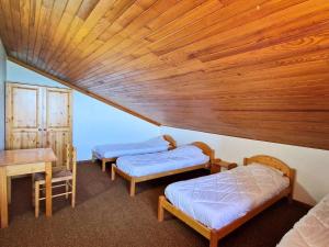 two beds in a room with a wooden ceiling at Grand appartement pour 12 pers. avec balcon sud, WIFI, parking et proche pistes – St Michel de Chaillol - FR-1-393-11 in Saint-Michel-de-Chaillol