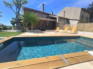 a pool with chairs and a house at Gîte - La Sabletine in Sablet