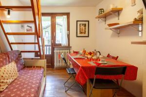 a small dining room with a table and a couch at Appartamento in stile alpino a Courmayeur in Verrand
