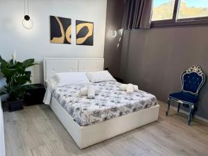a bedroom with a bed and a blue chair at Luxury Sofi in Giardini Naxos