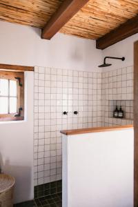 a bathroom with white tiled walls and a counter at Vineyard Cottage at Bosman Wines in Wellington