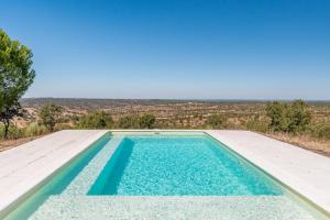 a swimming pool with a view of the desert at Authentic Alentejo Farmhouse in Arraiolos