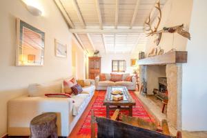 a living room with a couch and a fireplace at Authentic Alentejo Farmhouse in Arraiolos +40 photos