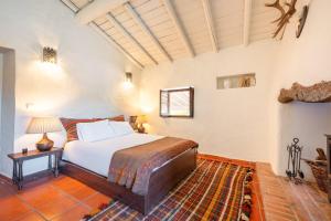 a bedroom with a bed and a table with a lamp at Authentic Alentejo Farmhouse in Arraiolos