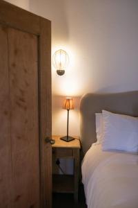 a bedroom with a bed and a lamp on a table at Vineyard Cottage at Bosman Wines in Wellington