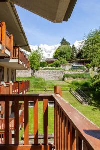 a wooden balcony with a view of a field at Appartamento in stile alpino a Courmayeur in Verrand