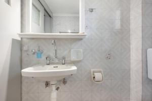 a white bathroom with a sink and a mirror at Apartment with garden view - Creta in Ferma
