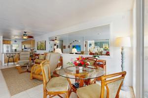 a living room with a glass table and chairs at Flip Flops & Sand Beach house in Wells