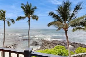 two palm trees on a beach with the ocean at Flip Flops & Sand Beach house in Wells