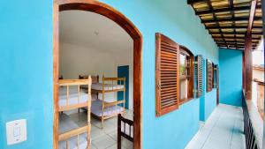 a room with bunk beds and a blue wall at Hostel Agatha in Paraty