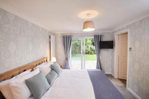 a bedroom with a bed and a sliding glass door at Sea Gem - large holiday cottage in Tenby with private parking in Tenby