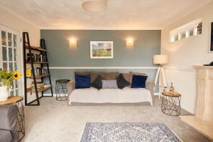 a living room with a couch and blue pillows at Sea Gem - large holiday cottage in Tenby with private parking in Tenby +25 photos