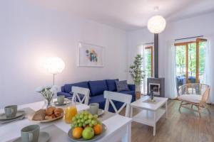 a living room with a blue couch and a table with fruits at Les Charmes C10 - Le Val Joly in Eppe-Sauvage +6 photos