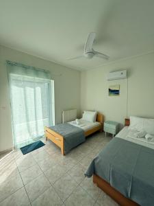 a bedroom with two beds and a window at Green House Schinias in Káto Soúlion