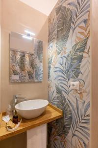 a bathroom with a sink and a mural of leaves at Lotus B&B in Messina